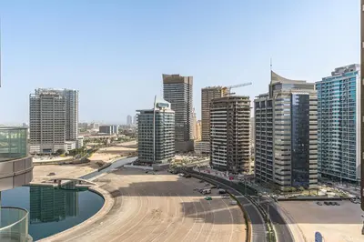 a view of a city with tall buildings at 2-Bedroom Haven with Canal View near The Els Club in Dubai