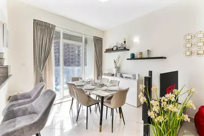 a kitchen and dining room with a table and chairs at 2-Bedroom Haven with Canal View near The Els Club in Dubai