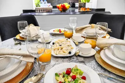 a table with plates of food and glasses of orange juice at Arabian Elegance 1BR Zanzabeel 1 Burj Khalifa View in Dubai