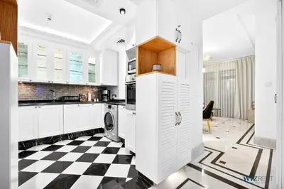 a kitchen with white cabinets and a checkered floor at Arabian Elegance 1BR Zanzabeel 1 Burj Khalifa View in Dubai
