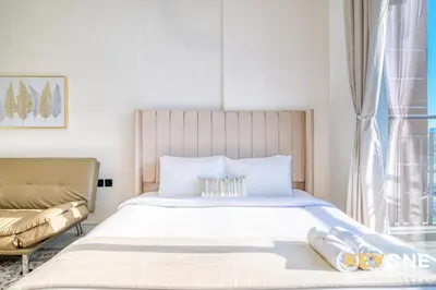 a bedroom with a large white bed and a couch at Elz Residence Stylish Studio Living in Dubai