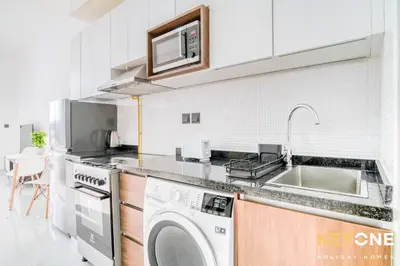 a kitchen with a washing machine and a sink at Elz Residence Stylish Studio Living in Dubai