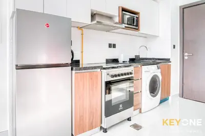 a kitchen with a refrigerator and a washing machine at Elz Residence Stylish Studio Living in Dubai