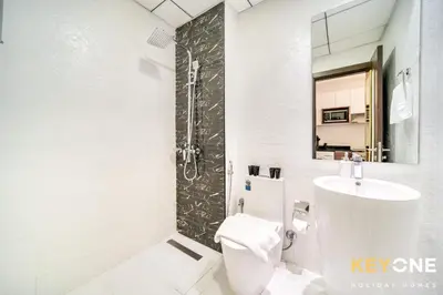 a bathroom with a toilet and a sink and a shower at Elz Residence Stylish Studio Living in Dubai
