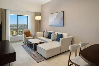 a living room with a couch and chairs and a table at Vintage Grand Hotel Apartments Dubai in Dubai