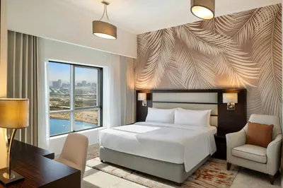 a bedroom with a bed and a desk and a chair at Vintage Grand Hotel Apartments Dubai in Dubai