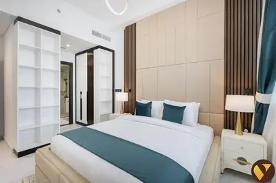 a bedroom with a large bed with blue pillows at Vogue Arjan Opalz by Danube near Science Park, One Bedroom Apartment with Balcony and Vibrant Community View, Access to all Amenitties in Dubai