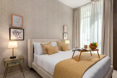 a bedroom with a large bed and a table at Maison Privee - Chic & Eclectic Family Home with Park Vws in Meydan in Dubai