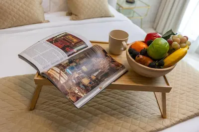 a table with a newspaper and a bowl of fruit at Maison Privee - Chic & Eclectic Family Home with Park Vws in Meydan in Dubai
