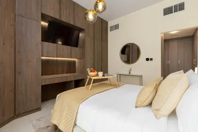 a bedroom with a large bed with a tv on the wall at Maison Privee - Chic & Eclectic Family Home with Park Vws in Meydan in Dubai