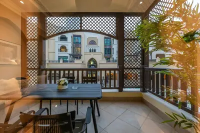 a balcony with a blue table and chairs and a building at Charming 1 BR with Burj Khalifa View in Dubai