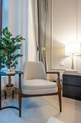 a living room with a chair and a table at Charming 1 BR with Burj Khalifa View in Dubai