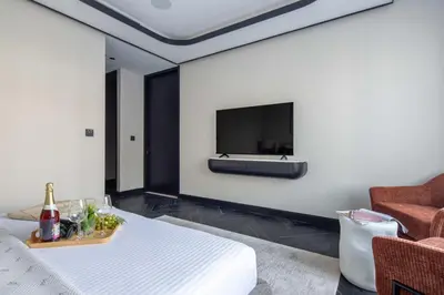a room with a bed and a tv on a wall at Frank Porter - J One Tower 2 in Dubai