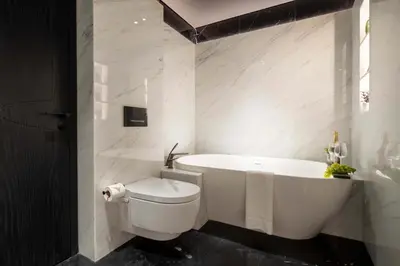 a white bathroom with a tub and a toilet at Frank Porter - J One Tower 2 in Dubai