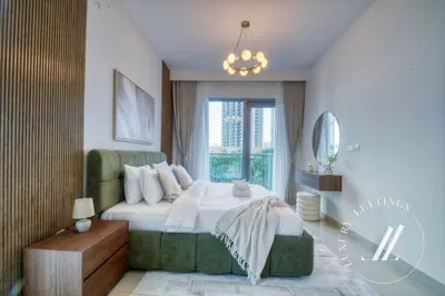 a bedroom with a large bed and a chandelier at Luxury 2BR Harbour Views Tower 2 Creek Harbour Dubai in Dubai