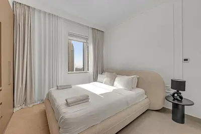 a white bedroom with a large bed and a window at 3 Bedroom in Creek Habour with Scenic Views for Family and Solo Travelers in Dubai