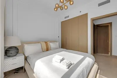 a bedroom with a large white bed and a lamp at 3 Bedroom in Creek Habour with Scenic Views for Family and Solo Travelers in Dubai