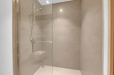 a bathroom with a glass shower with a toilet at 3 Bedroom in Creek Habour with Scenic Views for Family and Solo Travelers in Dubai