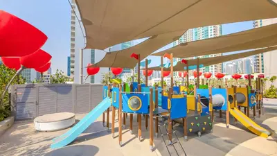 a playground with a slide in a city at TRPS - MAG 318, Business Bay - Pool View, 2BR Fully Furnished, Prime Location in Dubai