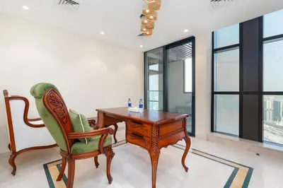 a desk and chair in a room with windows at Samaya Holiday Homes - Square 1B Duplex Panoramic View in Dubai
