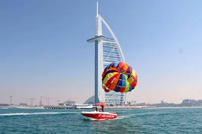 a person in a boat with a parachute in the water at Parasailing Boat Dubai in Dubai