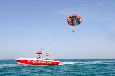a hot air balloon flying over a boat in the ocean at Parasailing Boat Dubai in Dubai