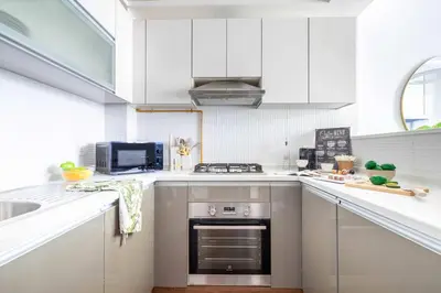 a kitchen with white cabinets and a stove top oven at Frank Porter - Glitz Residence 2 in Dubai