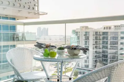 a table with a plate of food on a balcony at Frank Porter - Glitz Residence 2 in Dubai