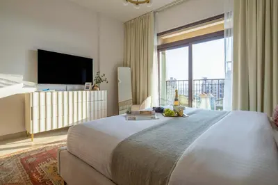 a bedroom with a large bed and a large window at Frank Porter - Jadeel 3 in Dubai