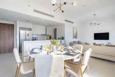 a dining room and kitchen with a table and chairs at Frank Porter - Jadeel 3 in Dubai