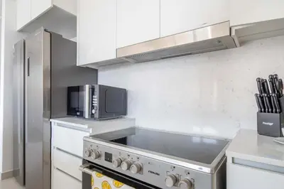 a kitchen with a stove and a microwave at Frank Porter - Jadeel 3 in Dubai