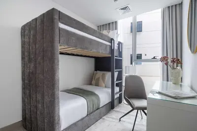 a small bedroom with a bunk bed with a desk and a desk at Frank Porter - Luma22 West Tower in Dubai