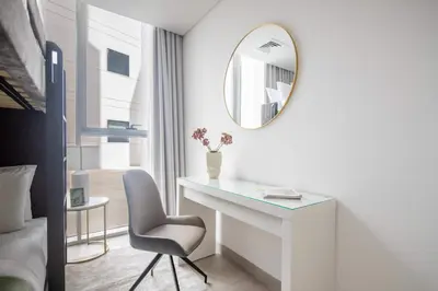 a bedroom with a desk and a mirror and a chair at Frank Porter - Luma22 West Tower in Dubai