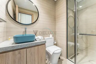 a bathroom with a toilet and a sink and a mirror at Studio with Dubai Canal View, Walking Distance to Metro Station and Near Downtown Dubai - Peninsula One, Business Bay by Deluxe Holiday Homes in Dubai