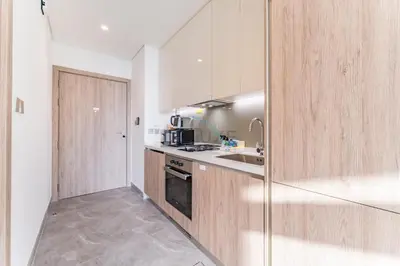 a kitchen with a sink and a stove top oven at Studio with Dubai Canal View, Walking Distance to Metro Station and Near Downtown Dubai - Peninsula One, Business Bay by Deluxe Holiday Homes in Dubai