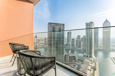a balcony with two chairs and a view of the city at Studio with Dubai Canal View, Walking Distance to Metro Station and Near Downtown Dubai - Peninsula One, Business Bay by Deluxe Holiday Homes in Dubai