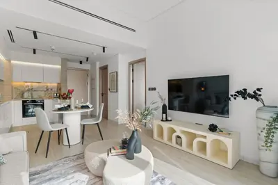 a living room with a large tv and a kitchen at The Smart Concierge - Bay Central in Dubai