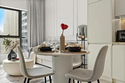 a dining room with a table and chairs with a vase at The Smart Concierge - Bay Central in Dubai