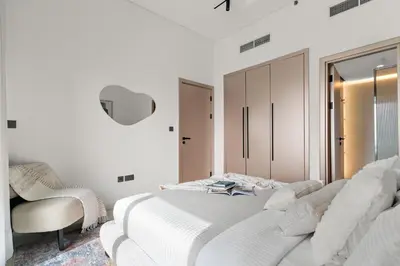 a white bedroom with a white bed and a chair at The Smart Concierge - Bay Central in Dubai