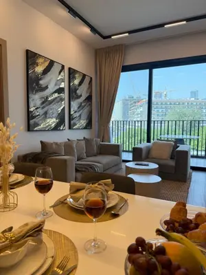 a living room with a couch and a table with wine glasses at Oakley Square Residence in Dubai