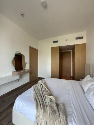 a bedroom with a large white bed and a tv at Oakley Square Residence in Dubai