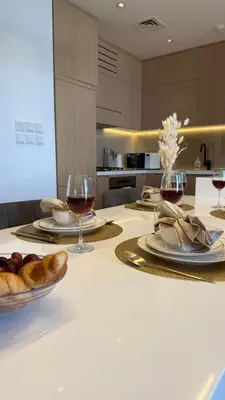 a table with two glasses of wine and bread on it at Oakley Square Residence in Dubai