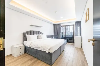 a bedroom with a large bed with white sheets at Escape24 Elegant 1BR in JVC with Pool View in Dubai