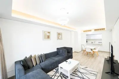 a living room with a couch and a table at Escape24 Elegant 1BR in JVC with Pool View in Dubai