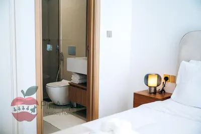 a bedroom with a bed and a bathroom with a toilet at Beautiful Brand New Spacious in Dubai