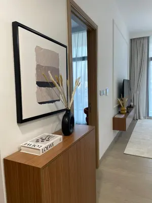 a living room with a book and a vase on a cabinet at Beautiful Brand New Spacious in Dubai