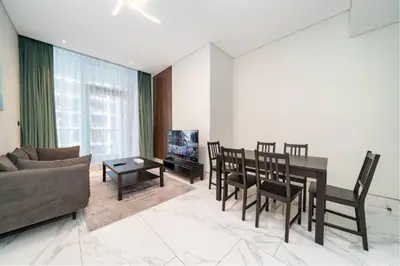 a living room with a couch and a dining room table at Chic and Urban 1-Bed Business Bay Suite in Dubai