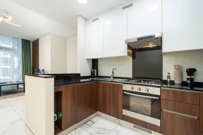 a kitchen with white cabinets and a stove top oven at Chic and Urban 1-Bed Business Bay Suite in Dubai