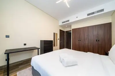 a bedroom with a white bed and a desk at Chic and Urban 1-Bed Business Bay Suite in Dubai