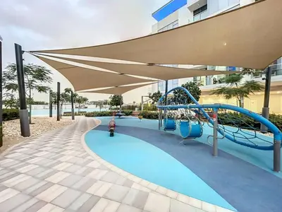 a playground with a slide and an umbrella at Vacationer l Serene 3 Bed Haven l Private Beach l District One in Dubai